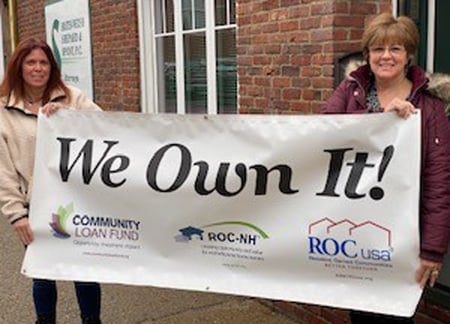Two Granite Estates Cooperative officers display their We Own It banner.