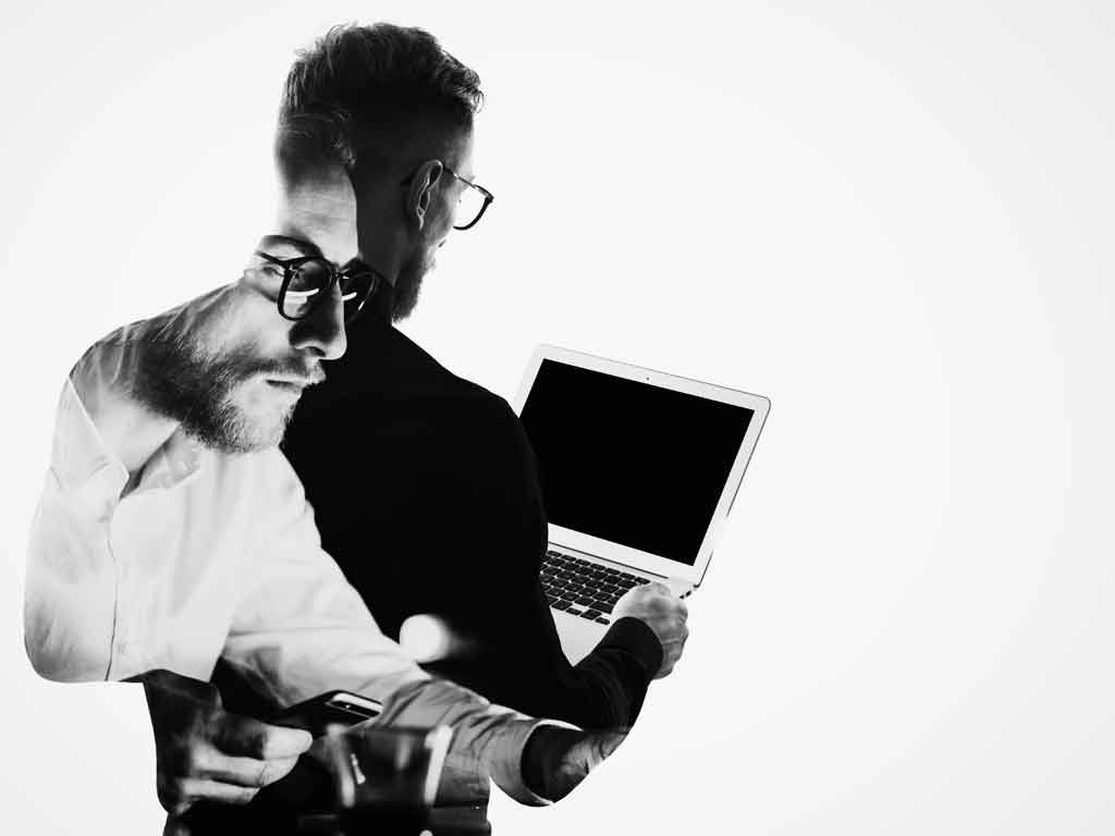 Double-exposure image of young businessman looking at laptop.